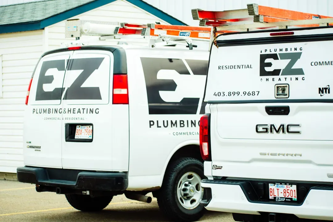 EZ Plumbing & Heating service vans wearing their Live Dogs fleet rebrand in Airdrie